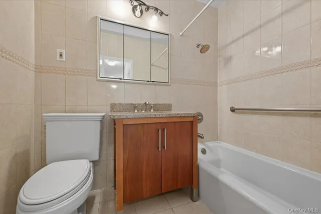 a bathroom with a granite countertop toilet sink and mirror