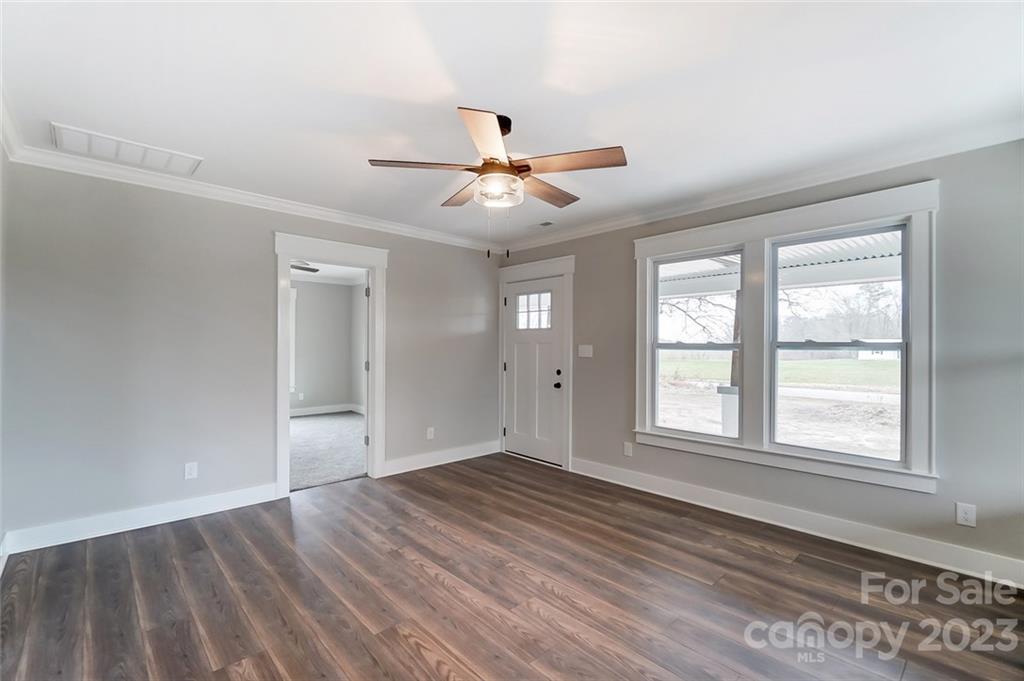 3711 Sikes Mill Road Monroe, NC 28110 - Photo 11 of 46 an empty room with wooden floor ceiling fan and windows