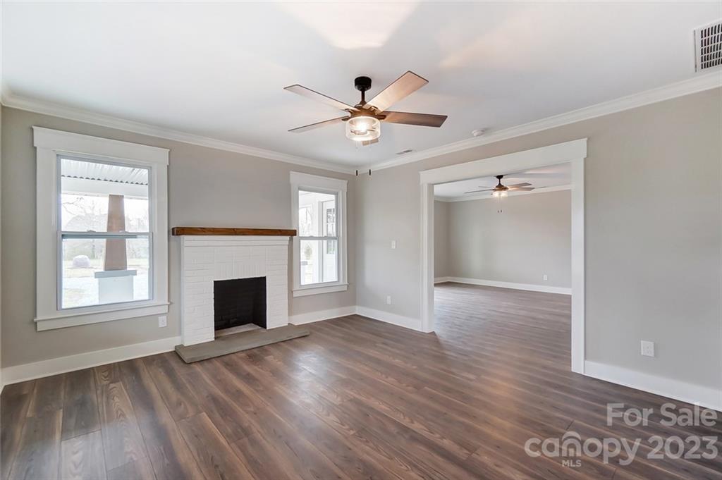 3711 Sikes Mill Road Monroe, NC 28110 - Photo 13 of 46 a view of an empty room with wooden floor fireplace and a window