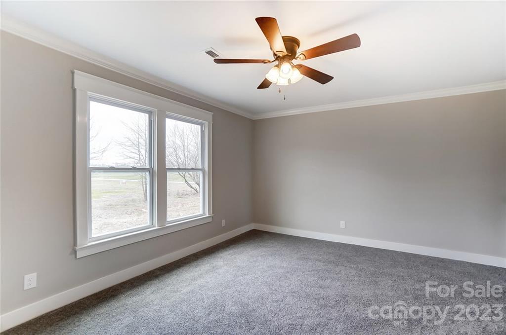 3711 Sikes Mill Road Monroe, NC 28110 - Photo 29 of 46 an empty room with window and ceiling fan