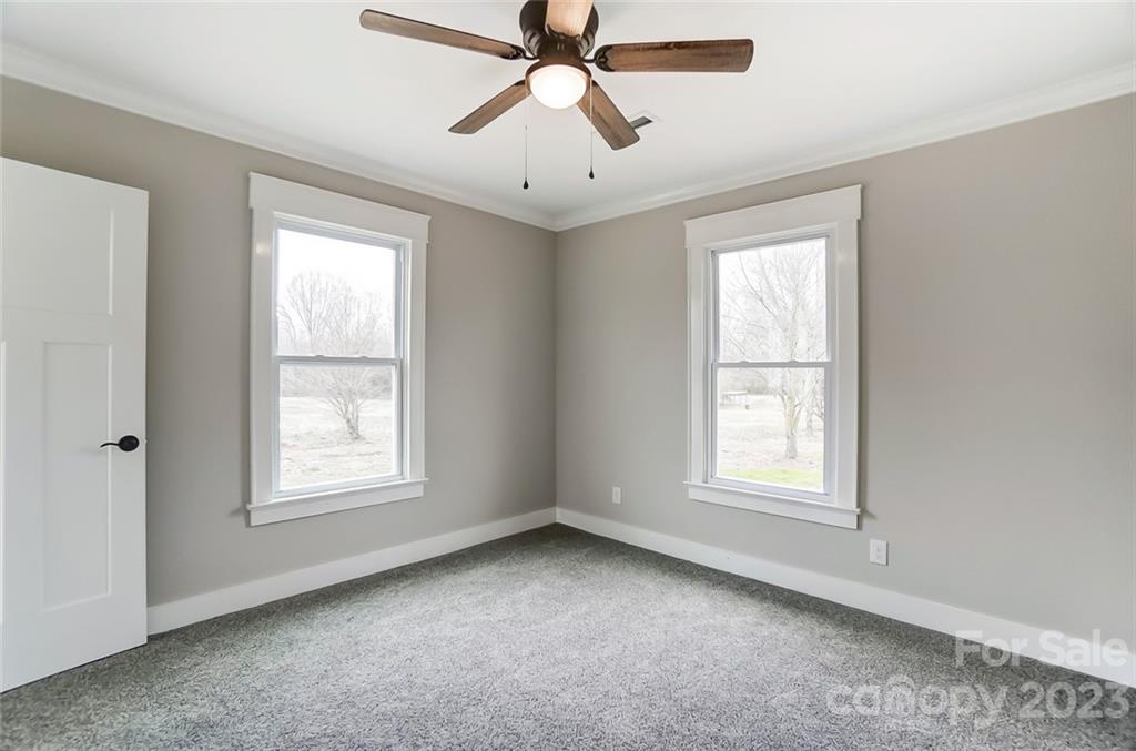 3711 Sikes Mill Road Monroe, NC 28110 - Photo 38 of 46 an empty room with chandelier fan and windows