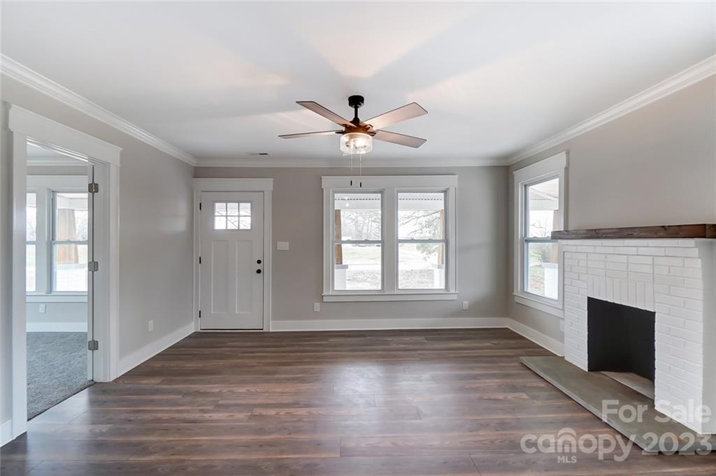 3711 Sikes Mill Road Monroe, NC 28110 - Photo 10 of 46 an empty room with wooden floor fireplace and windows