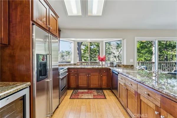 a kitchen with stainless steel appliances granite countertop a refrigerator and wooden cabinets