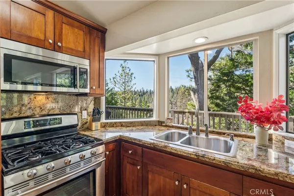 a kitchen with granite countertop a stove sink and microwave