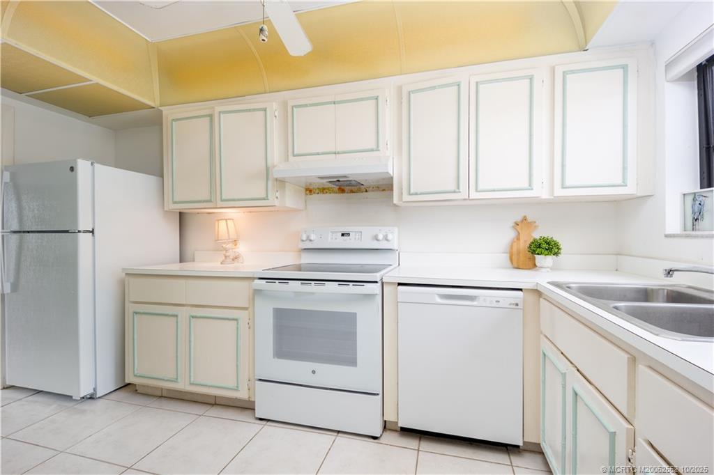 3901 Southeast St Lucie Boulevard, Unit B14 Stuart, FL 34997 - Photo 12 of 37 a kitchen with white cabinets and white appliances
