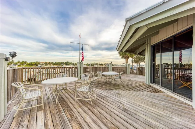 an aerial view of residential houses with outdoor space and lake view in back