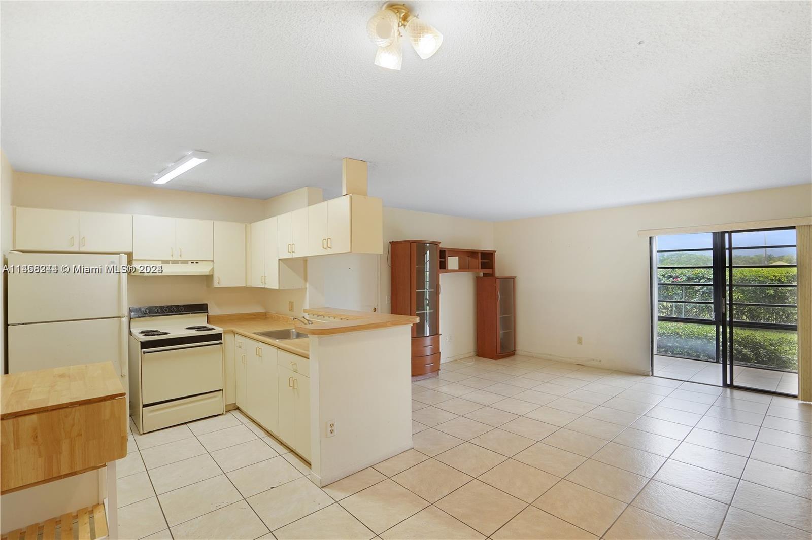 9727 Hammocks Boulevard, Unit 103D Miami, FL 33196 - Photo 1 of 11 a kitchen with cabinets and steel stainless steel appliances