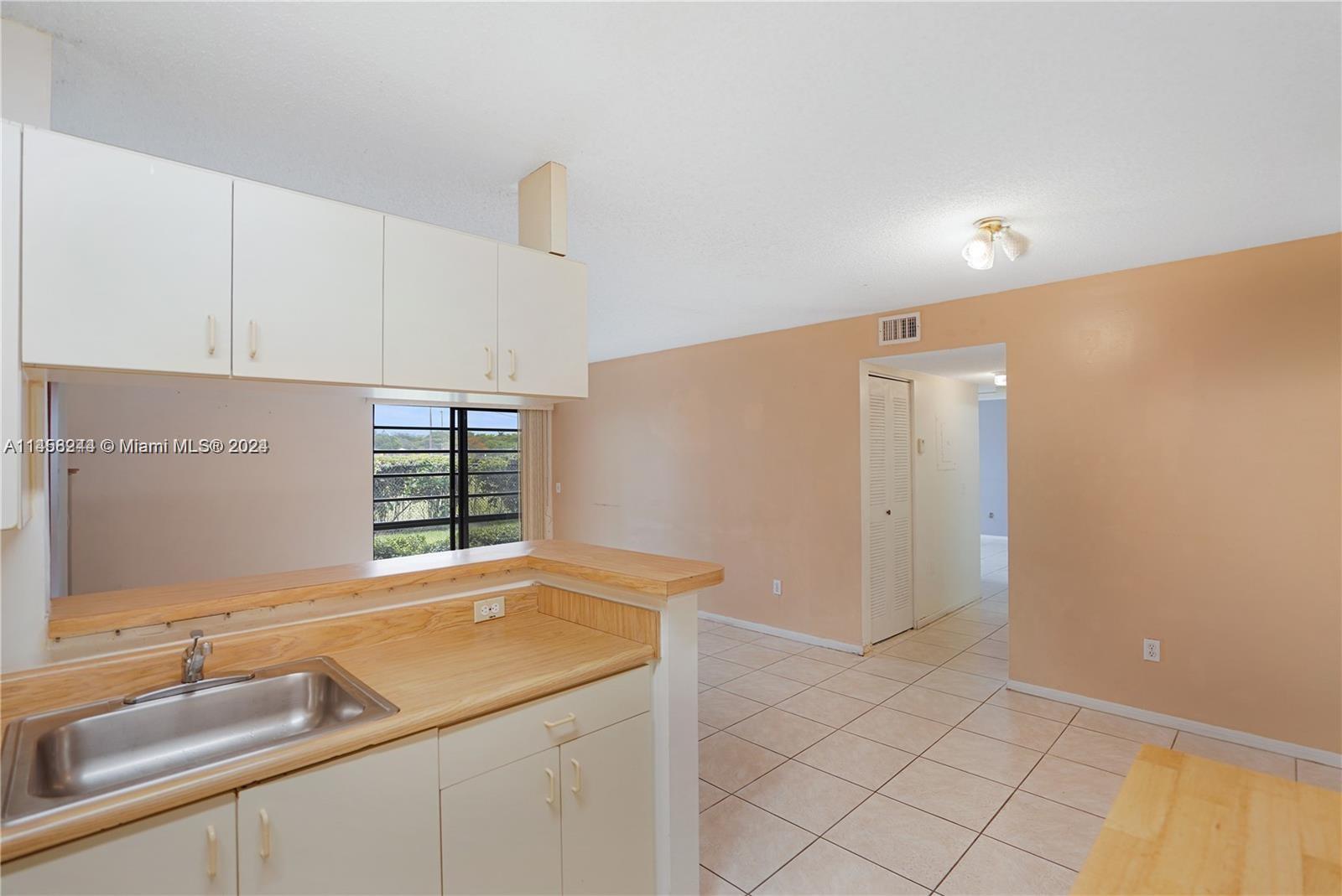 9727 Hammocks Boulevard, Unit 103D Miami, FL 33196 - Photo 11 of 11 a kitchen with a sink and cabinets