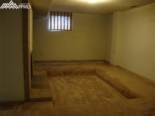 2965 Valencia Road Colorado Springs, CO 80917 - Photo 18 of 22 Basement family room offers a "conversation pit" stay warm and cozy with the gas fireplace.