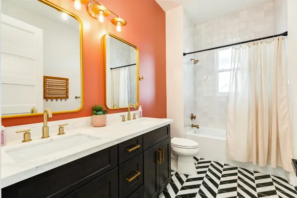 a bathroom with a double vanity sink toilet and a mirror