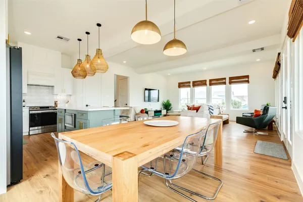 a view of a dining room and livingroom with furniture wooden floor and a chandelier