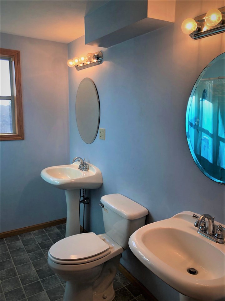 1904 Ridgeland Road Rockford, IL 61108 - Photo 11 of 20 a bathroom with a toilet a sink and mirror