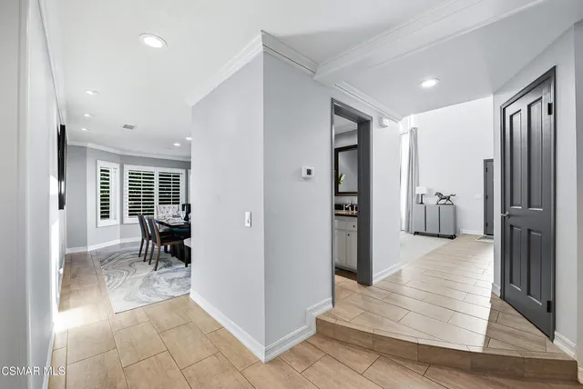 a view of a hallway with wooden floor and furniture