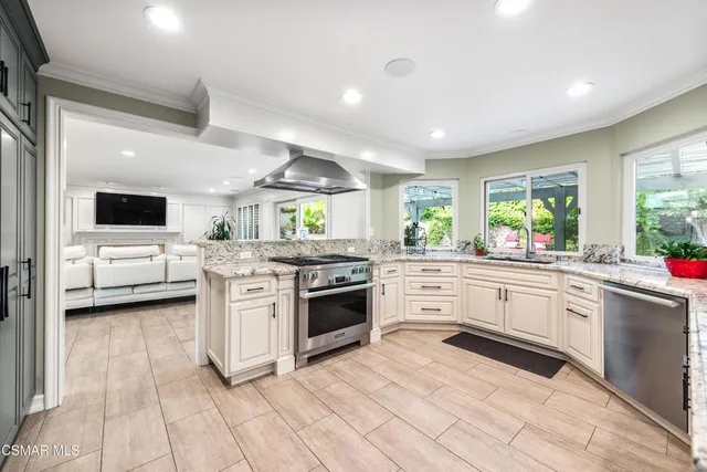 a kitchen with stainless steel appliances kitchen island granite countertop a stove and a sink