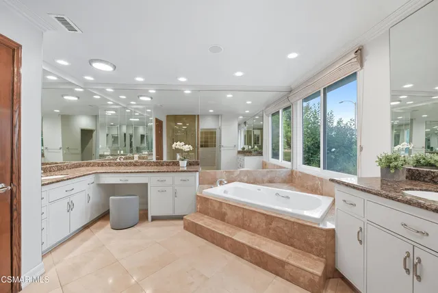 a spacious bathroom with a large tub and sink