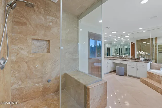 a large bathroom with a double vanity sink a toilet a mirror and shower