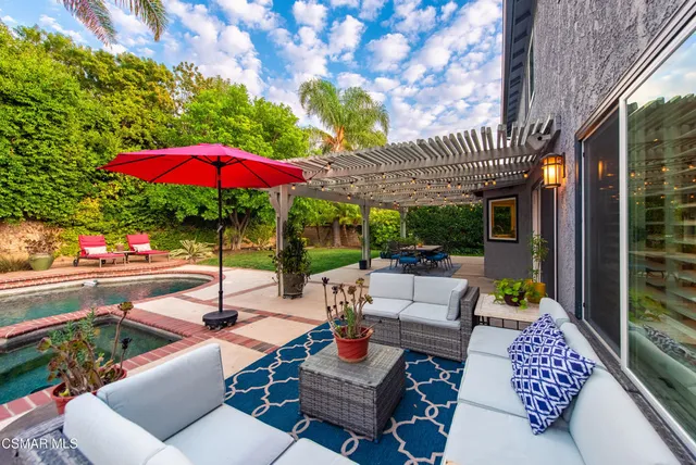 a view of a patio with couches table and chairs with an umbrella