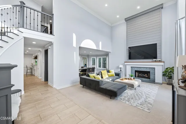 a living room with furniture a fireplace and a flat screen tv