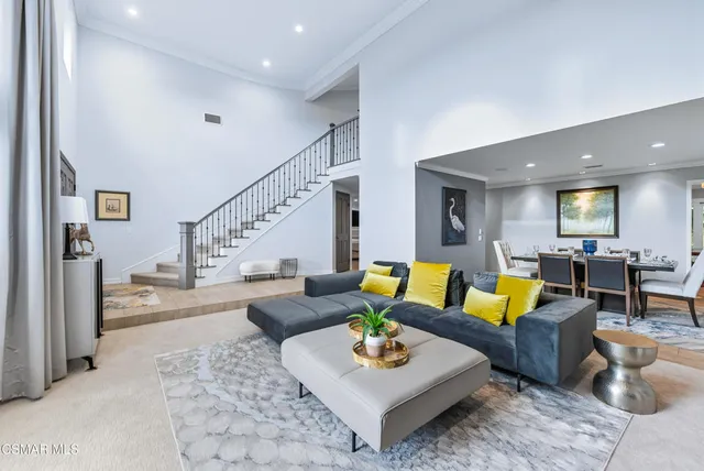 a living room with furniture kitchen view and a rug