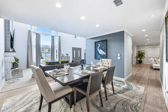 a dining room with furniture and a floor to ceiling window