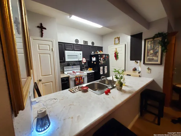 a kitchen with stainless steel appliances a dining table and chairs in it