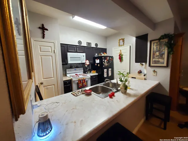 a kitchen with stainless steel appliances a dining table and chairs in it