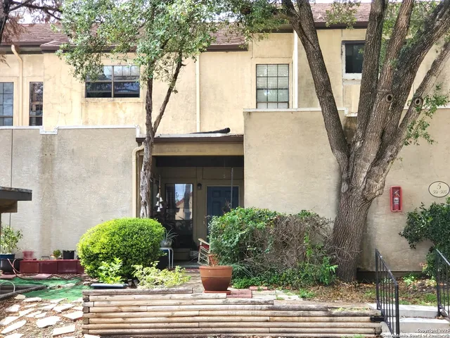 a view of a house with a tree in front
