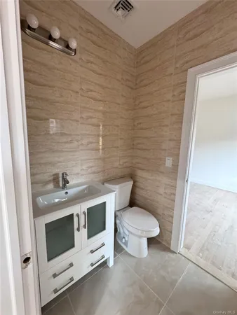 a bathroom with a toilet a sink and mirror