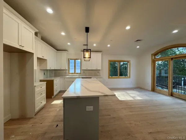 a kitchen with kitchen island a counter top space a sink stainless steel appliances and cabinets