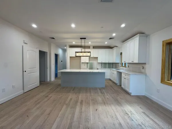 a view of a hallway with kitchen and a refrigerator