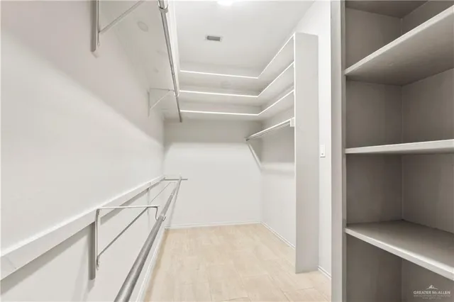 a view of staircase with railing and white walls