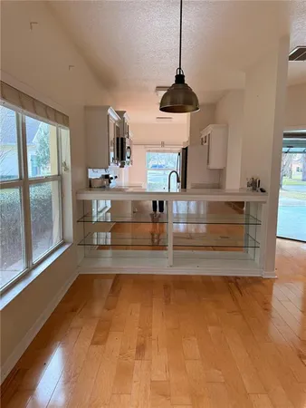 a view of a room with wooden floor windows and a chandelier