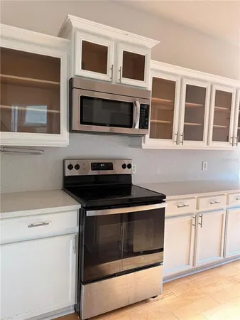 a kitchen with stainless steel appliances granite countertop white cabinets and black stove top oven
