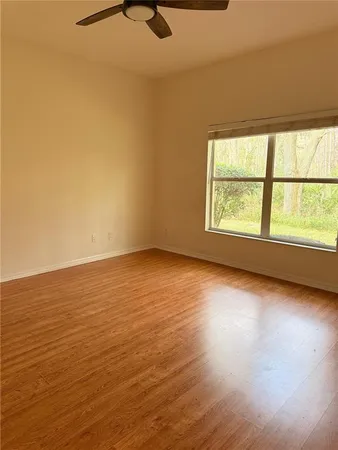 an empty room with wooden floor and windows