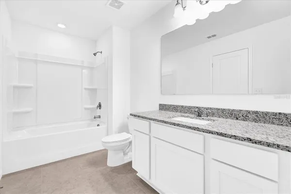 a bathroom with a granite countertop sink a toilet and bathtub