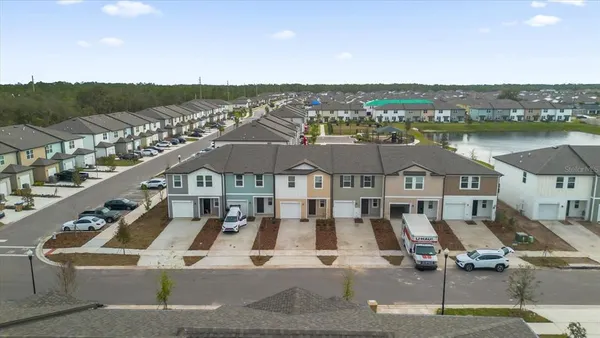 a view of a big house with a big yard and large buildings