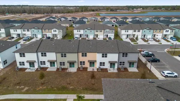 an aerial view of residential houses with outdoor space and ocean view