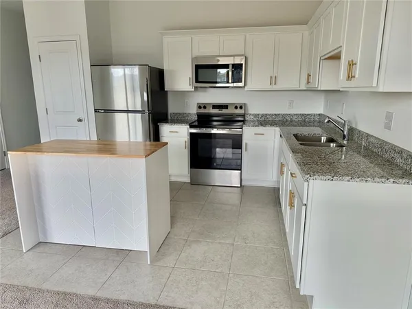 a kitchen with cabinets and stainless steel appliances
