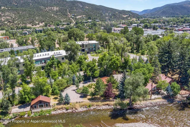 an aerial view of a house with a yard and lake view