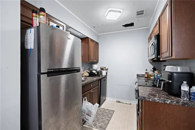 a kitchen with stainless steel appliances granite countertop a refrigerator and a stove top oven
