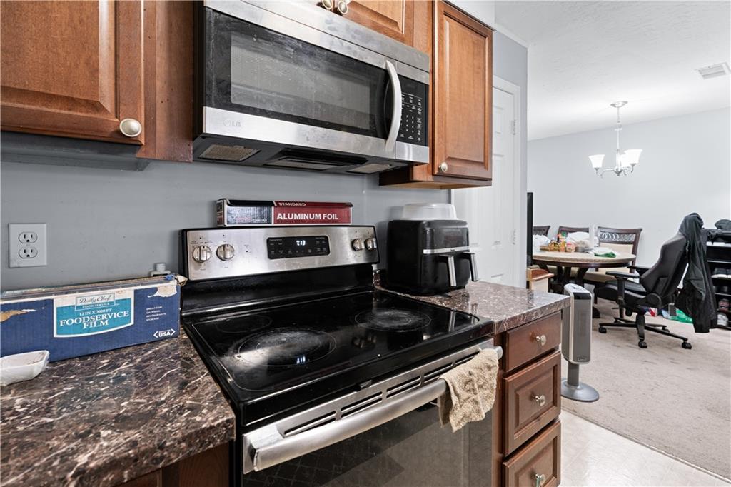237 Chads Ford Way Roswell, GA 30076 - Photo 9 of 22 a kitchen with stainless steel appliances granite countertop a stove and a microwave