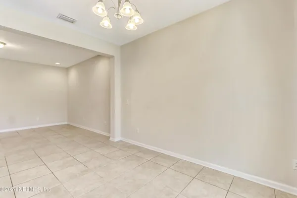 an empty room with kitchen view