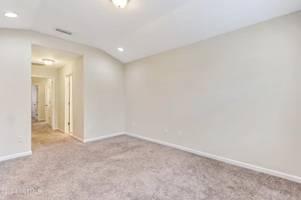 an empty room with an entryway and closet area
