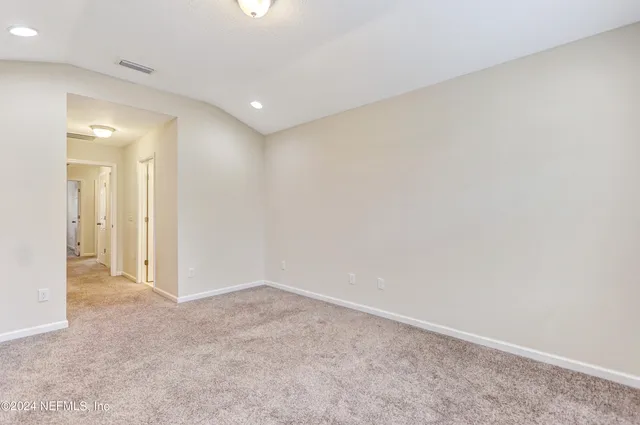 an empty room with an entryway and closet area