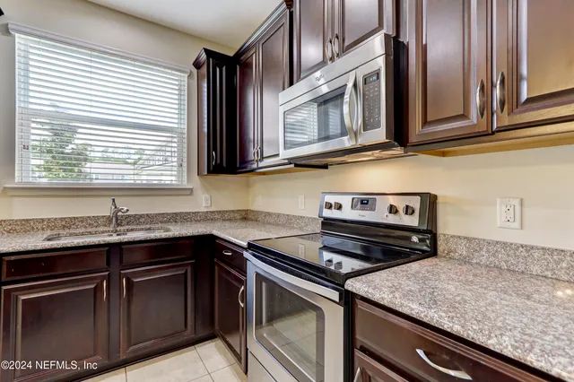 a kitchen with stainless steel appliances granite countertop a sink stove and microwave