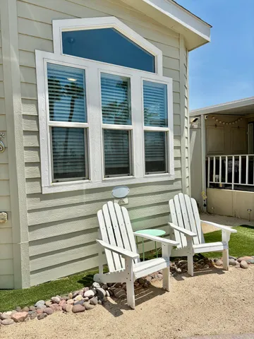 a view of a chair and tables in the back yard of the house