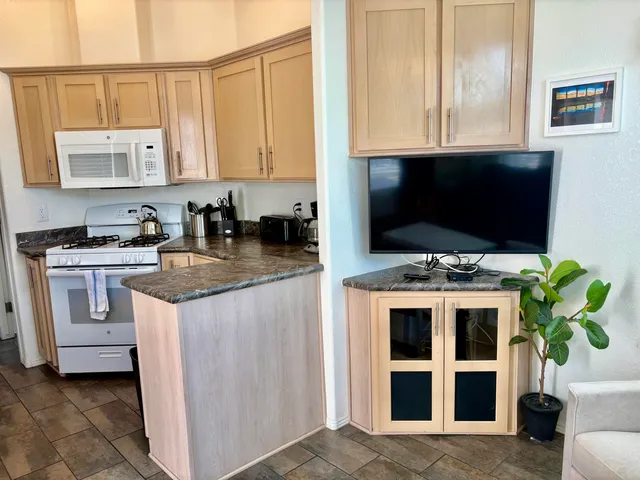 a view of kitchen with microwave stove refrigerator and cabinets