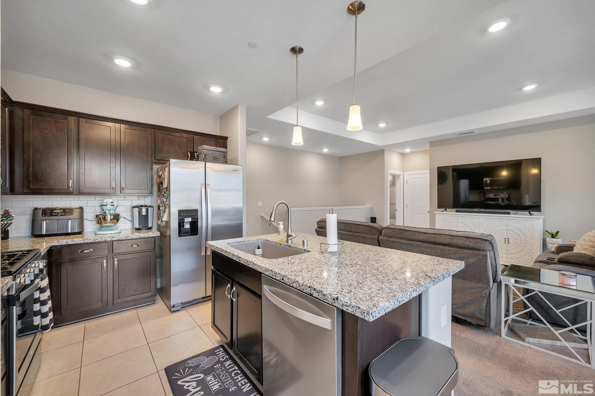 1914 Sea Horse Road, Unit A Reno, NV 89521 - Photo 8 of 28 a kitchen with stainless steel appliances granite countertop a stove a sink a microwave a refrigerator and chairs