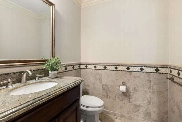 a bathroom with a granite countertop sink a toilet and a mirror