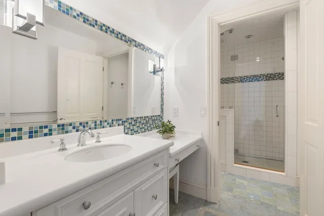 a bathroom with a shower sink and mirror